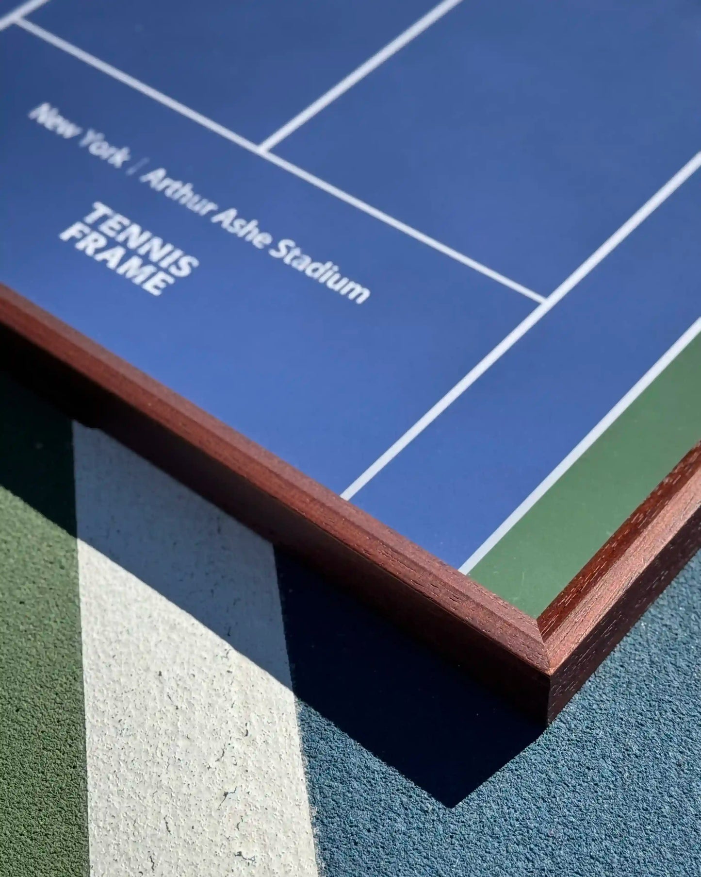 US Open Tennis Frame corner detail with wood frame edge and Arthur Ashe Stadium blue court graphic on outdoor court