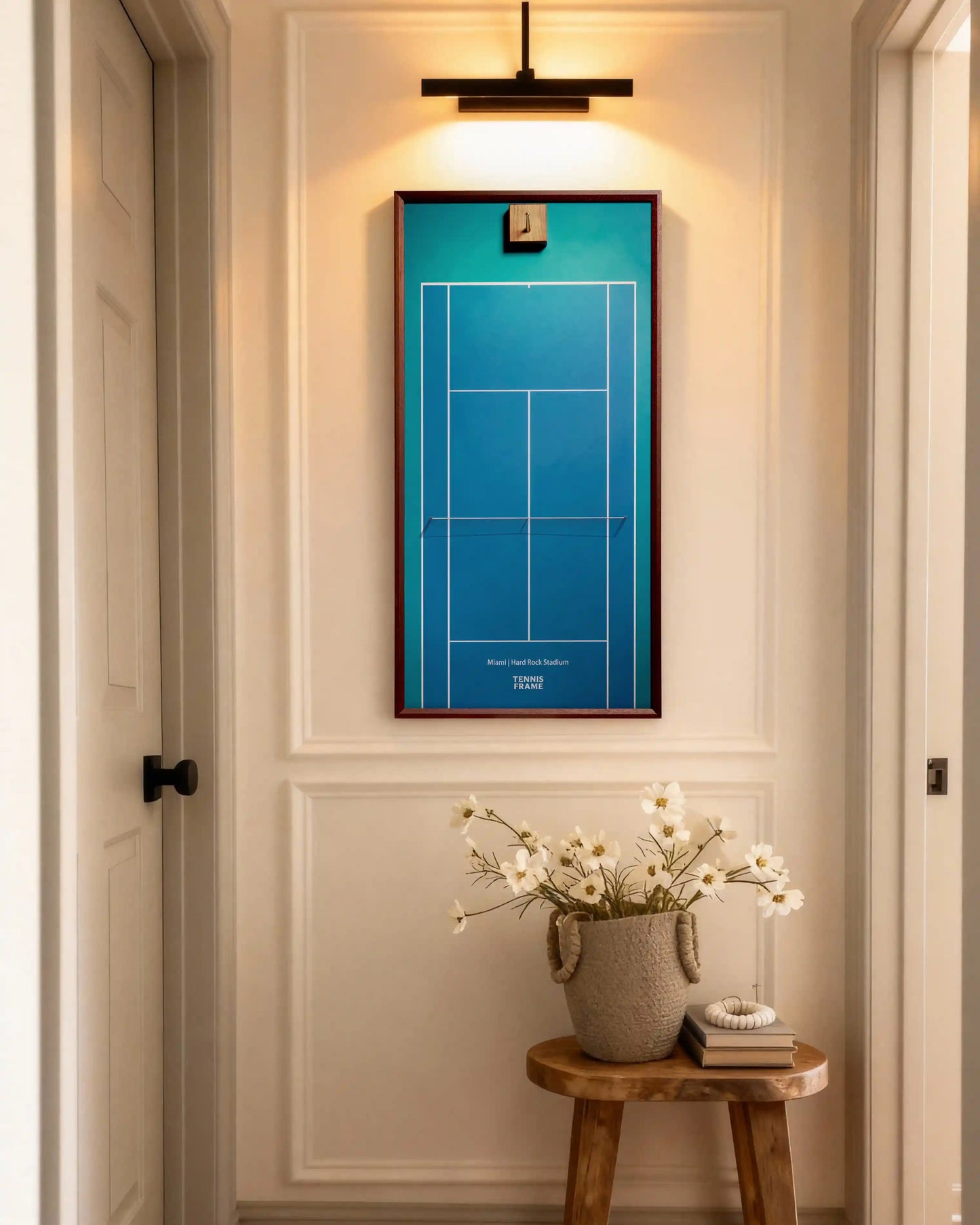 Miami Open tennis racket display frame with blue Hard Rock Stadium court design, walnut wood, styled in a modern hallway above a stool with flowers