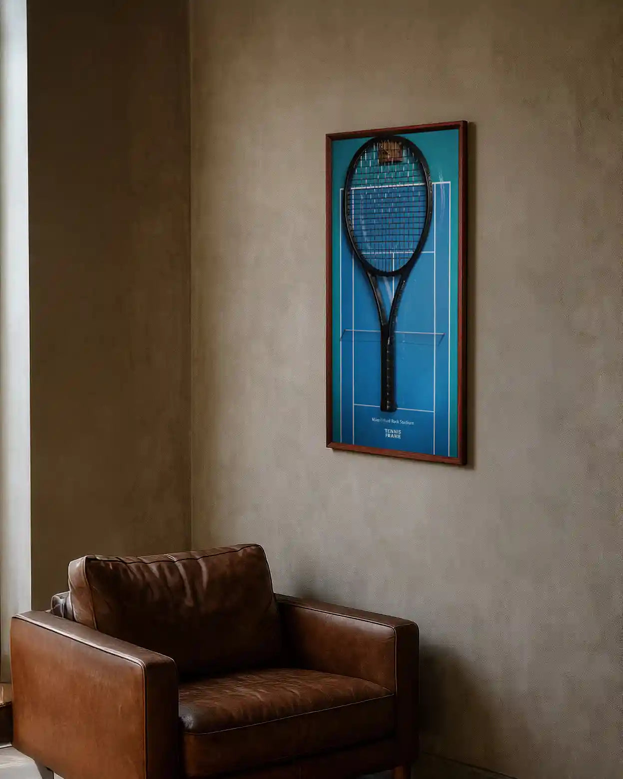 Miami Open tennis racket display frame with blue Hard Rock Stadium court design and walnut wood, mounted above a leather armchair in a cozy reading nook