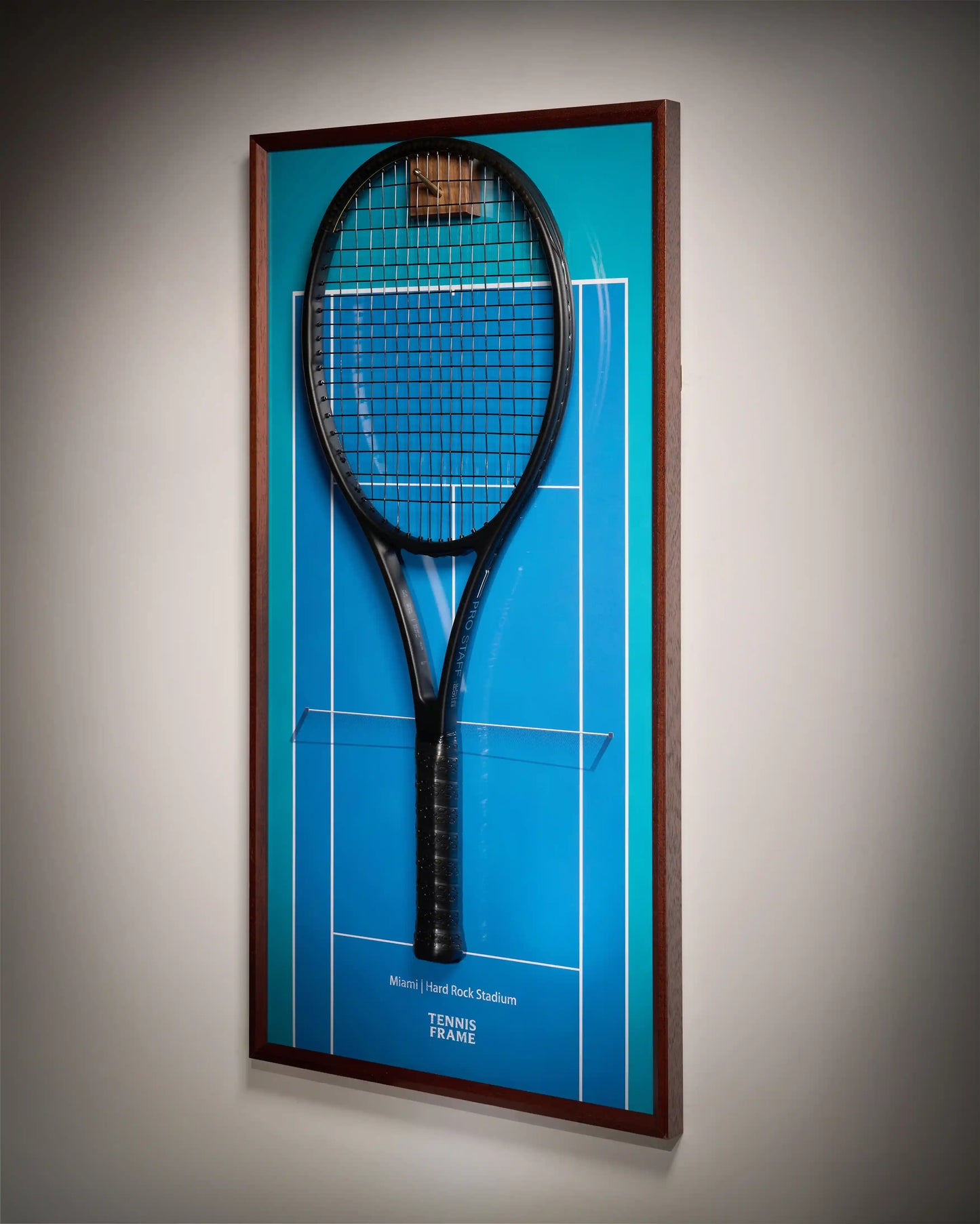 Miami Open tennis racket display frame with blue hard-court background at Hard Rock Stadium, angled side view with walnut frame and hook