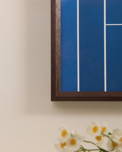 Close-up of walnut wood frame corner on Australian Open tennis frame with blue court background