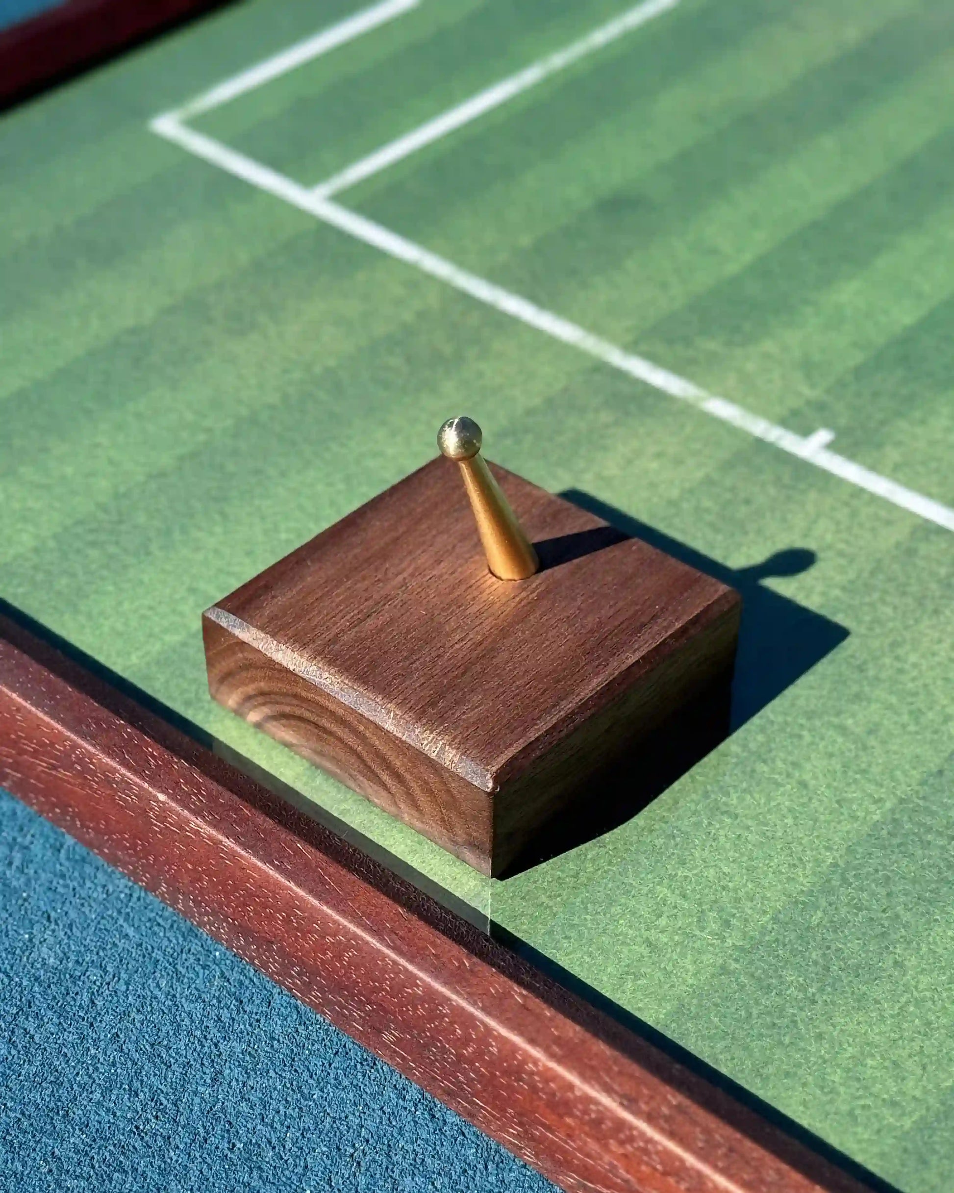 Close-up of walnut hook with brass peg on grass-court tennis frame