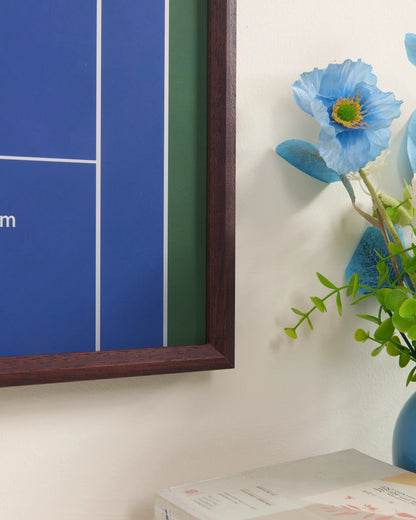 Close-up of US Open tennis frame corner with walnut wood and blue court background detail.