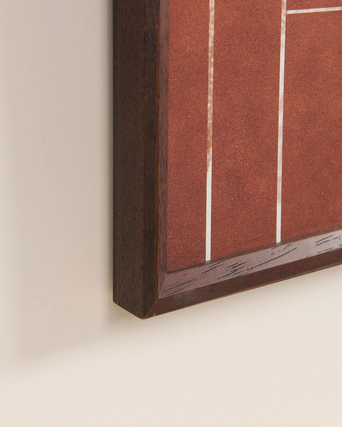 Close-up of walnut wood frame corner and clay court texture, showcasing premium craftsmanship of tennis racket display frame